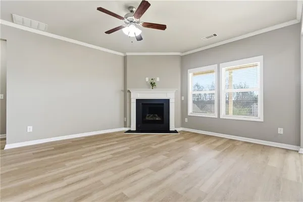 a view of an empty room with a window and fireplace
