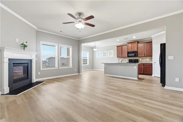 a view of a kitchen with a sink stove cabinets and empty room