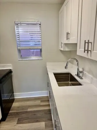 a kitchen with white cabinets and a sink