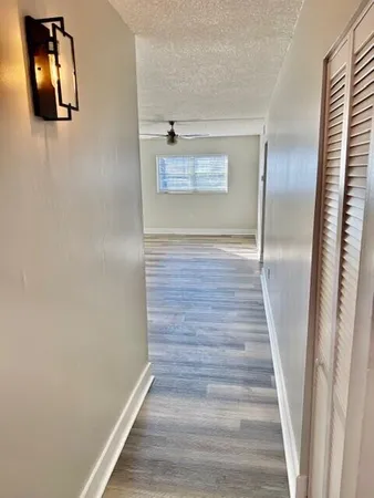 a view of a hallway with wooden floor