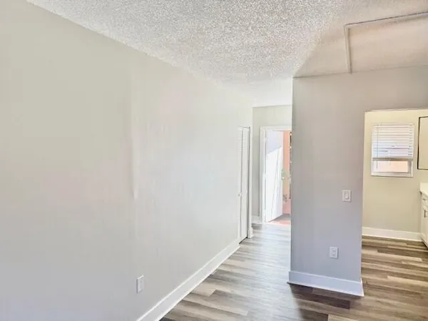 a view of a hallway with wooden floor and staircase