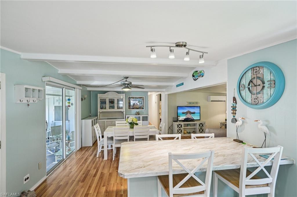 104 Willow Lane, Unit 30 Naples, FL 34114 - Photo 12 of 30 Dining area with wood finished floors, a wall unit AC, ceiling fan, and beamed ceiling