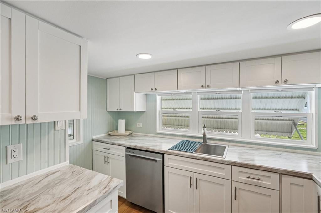 104 Willow Lane, Unit 30 Naples, FL 34114 - Photo 16 of 30 Kitchen with dishwasher, white cabinetry, and wood finished floors
