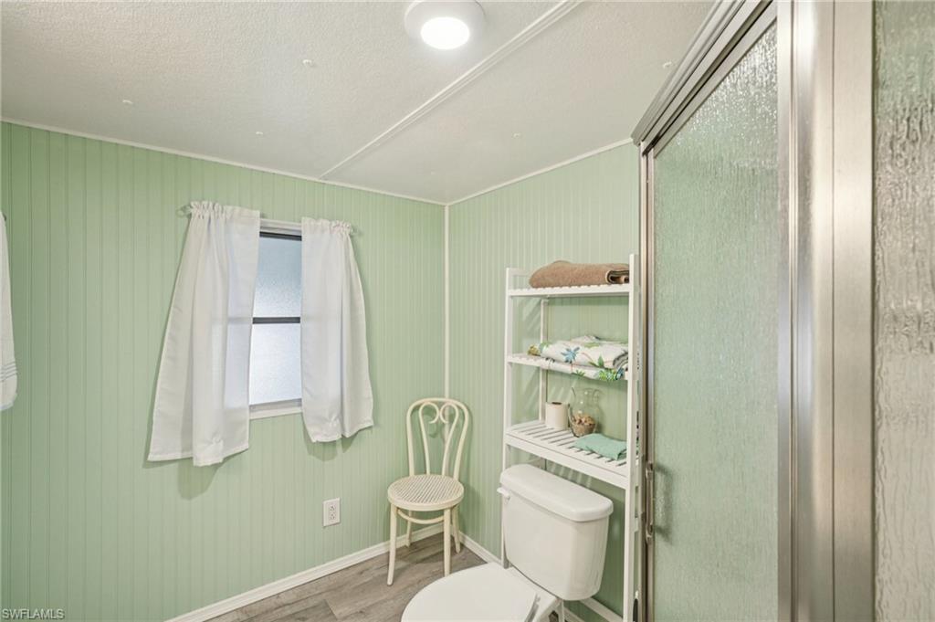 104 Willow Lane, Unit 30 Naples, FL 34114 - Photo 19 of 30 Bathroom with wood finished floors, a stall shower, and ornamental molding
