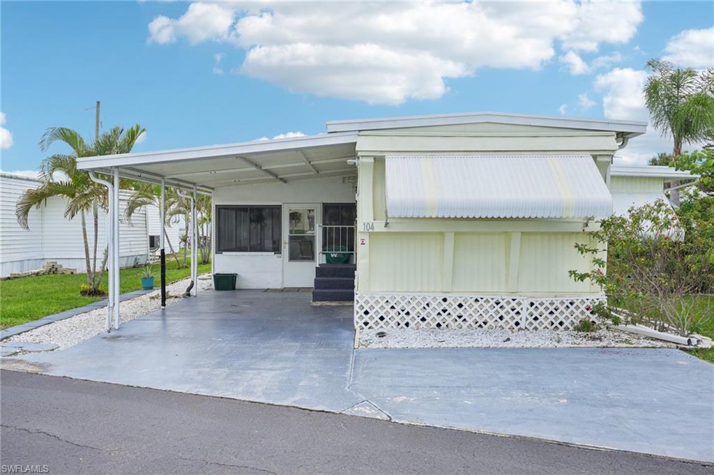 104 Willow Lane, Unit 30 Naples, FL 34114 - Photo 4 of 30 Mobile home with entry steps, a carport, and a sunroom