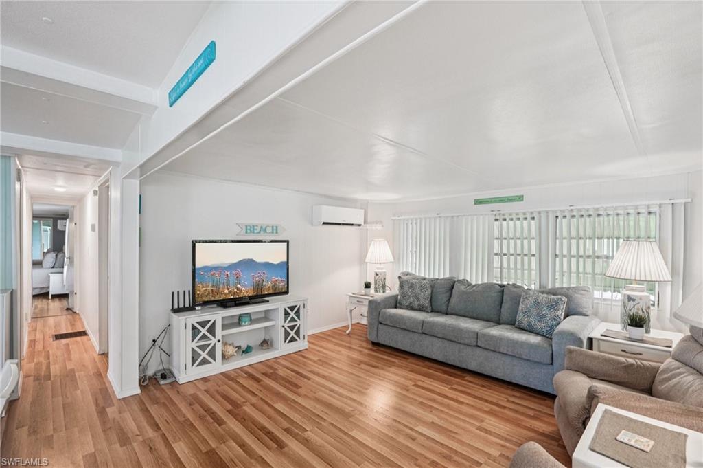 104 Willow Lane, Unit 30 Naples, FL 34114 - Photo 7 of 30 Living room featuring a wall mounted air conditioner and light wood-type flooring