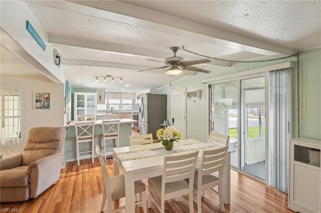 104 Willow Lane, Unit 30 Naples, FL 34114 - Photo 9 of 30 Dining space featuring light wood-style flooring, plenty of natural light, beamed ceiling, ceiling fan, and a textured ceiling