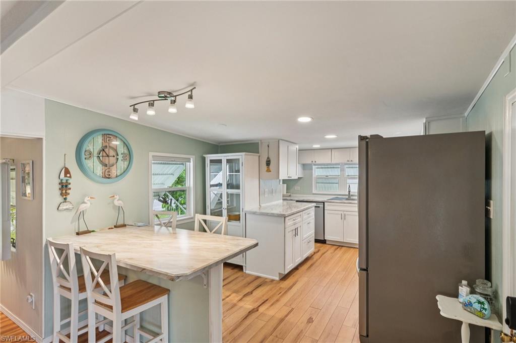 104 Willow Lane, Unit 30 Naples, FL 34114 - Photo 10 of 30 Kitchen with appliances with stainless steel finishes, plenty of natural light, white cabinetry, light wood-style floors, and recessed lighting