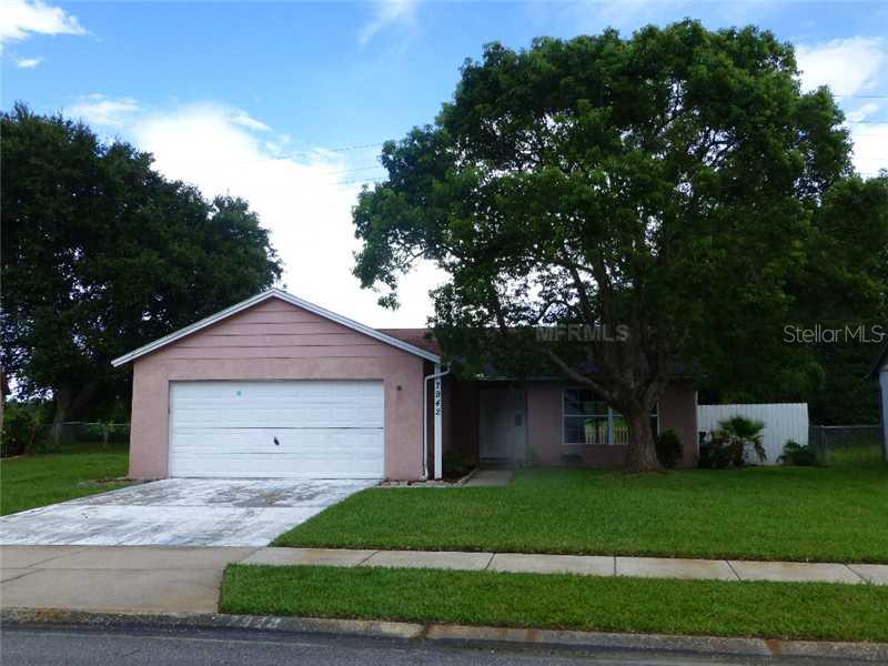7942 Adelaide Loop New Port Richey, FL 34655 - Photo 1 of 1 a front view of a house with a yard and garage