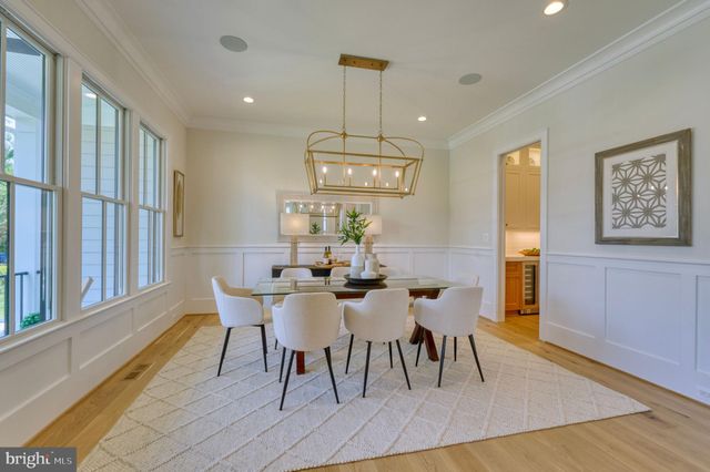 a bathroom with a toilet a sink a mirror and a window