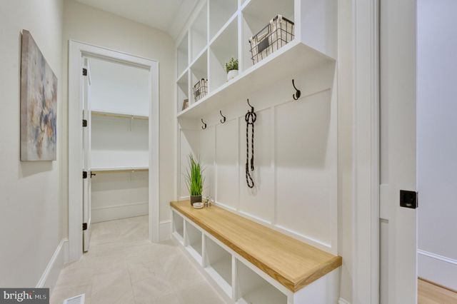 a spacious bedroom with a large bed a chandelier and windows