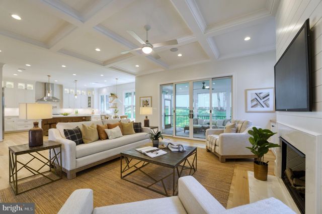a living room with furniture kitchen view and a flat screen tv