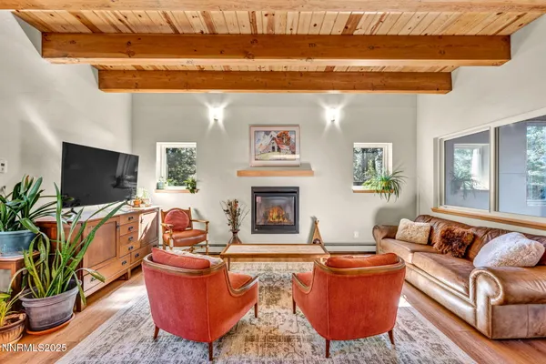 a kitchen with stainless steel appliances a dining table chairs and wooden floors