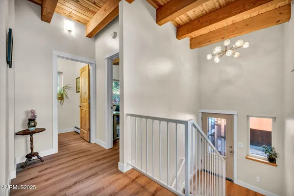 a kitchen with stainless steel appliances granite countertop a refrigerator a sink dishwasher a dining table and chairs with wooden floor