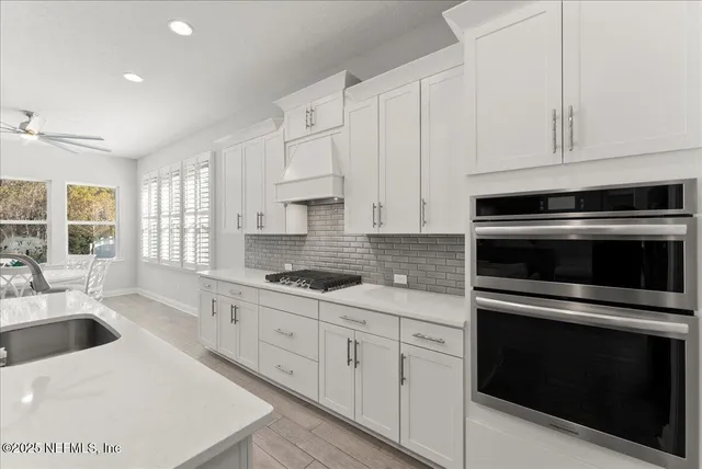 a kitchen with granite countertop white cabinets and appliances