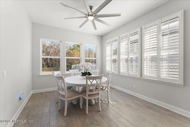a dining room with furniture a chandelier and wooden floor
