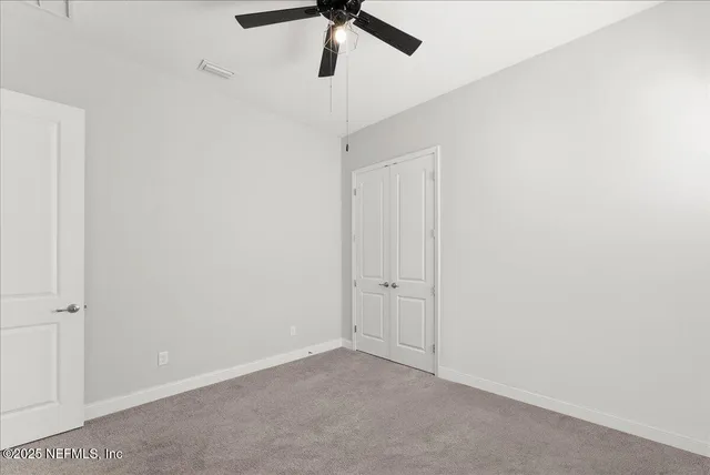 an empty room with a ceiling fan and window