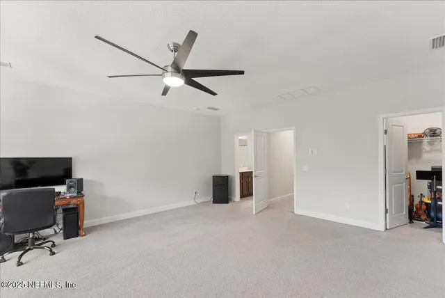 a view of a workspace with furniture and a ceiling fan
