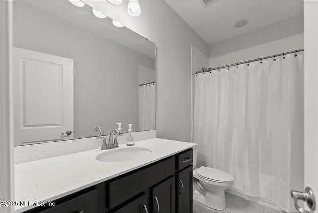 a bathroom with a double vanity sink toilet and a mirror