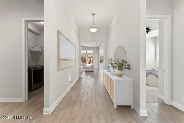 a view of a hallway with wooden floor windows and a bathroom
