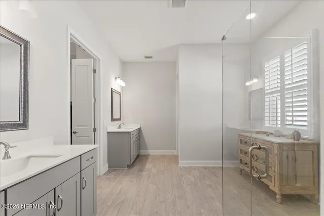 a bathroom with a granite countertop sink mirror and a bathtub