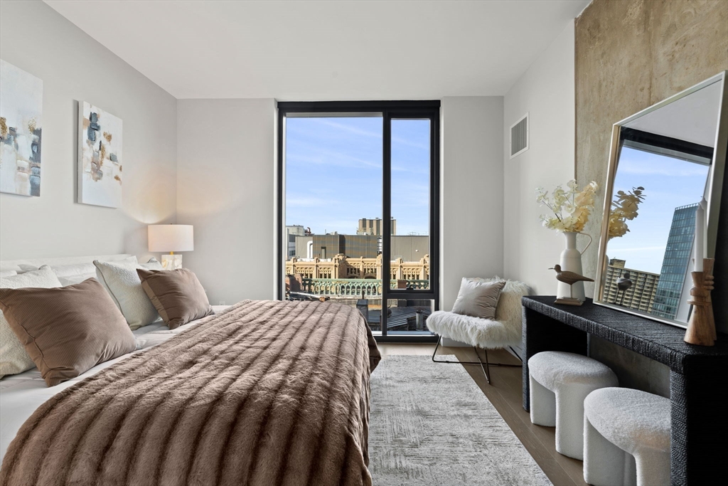 55 Lagrange Street, Unit 1703 Boston, MA 02111 - Photo 13 of 33 a bedroom with a bed and glass window