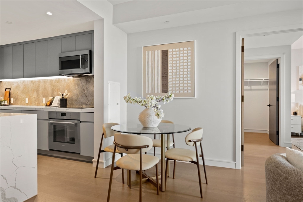 55 Lagrange Street, Unit 1703 Boston, MA 02111 - Photo 5 of 33 a kitchen with stainless steel appliances kitchen island granite countertop a table and chairs in it