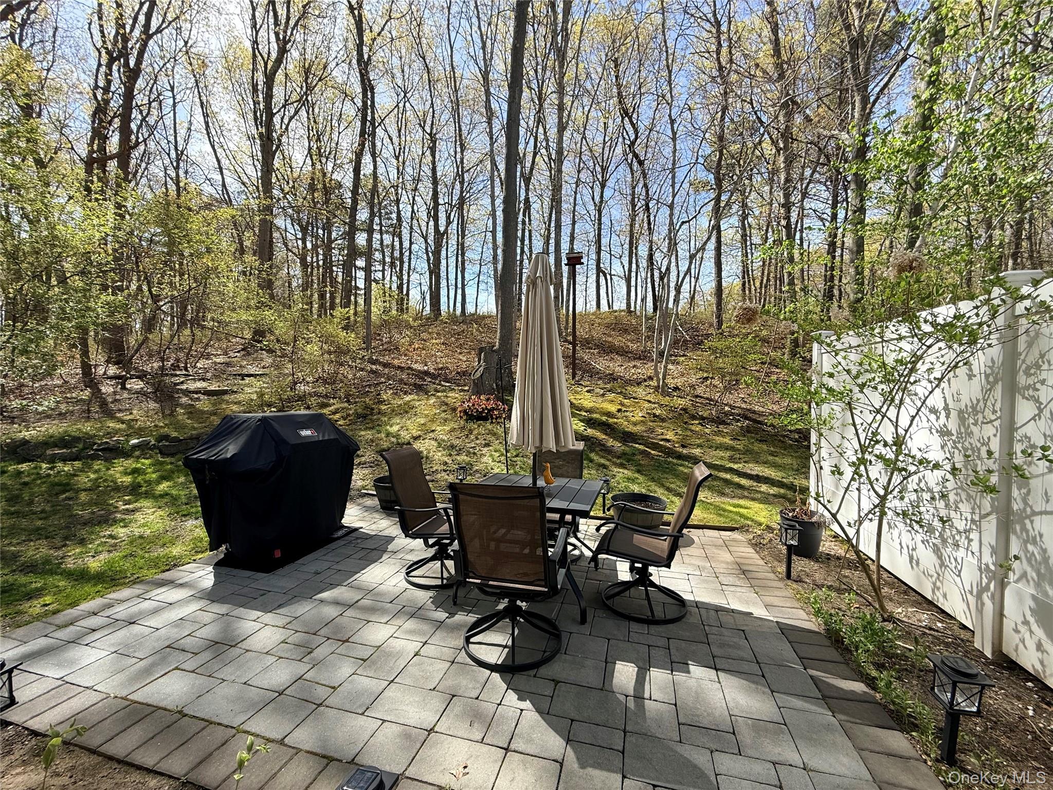 9 Penn Commons Yaphank, NY 11980 - Photo 22 of 34 a view of a patio with couple of chairs and a fire pit