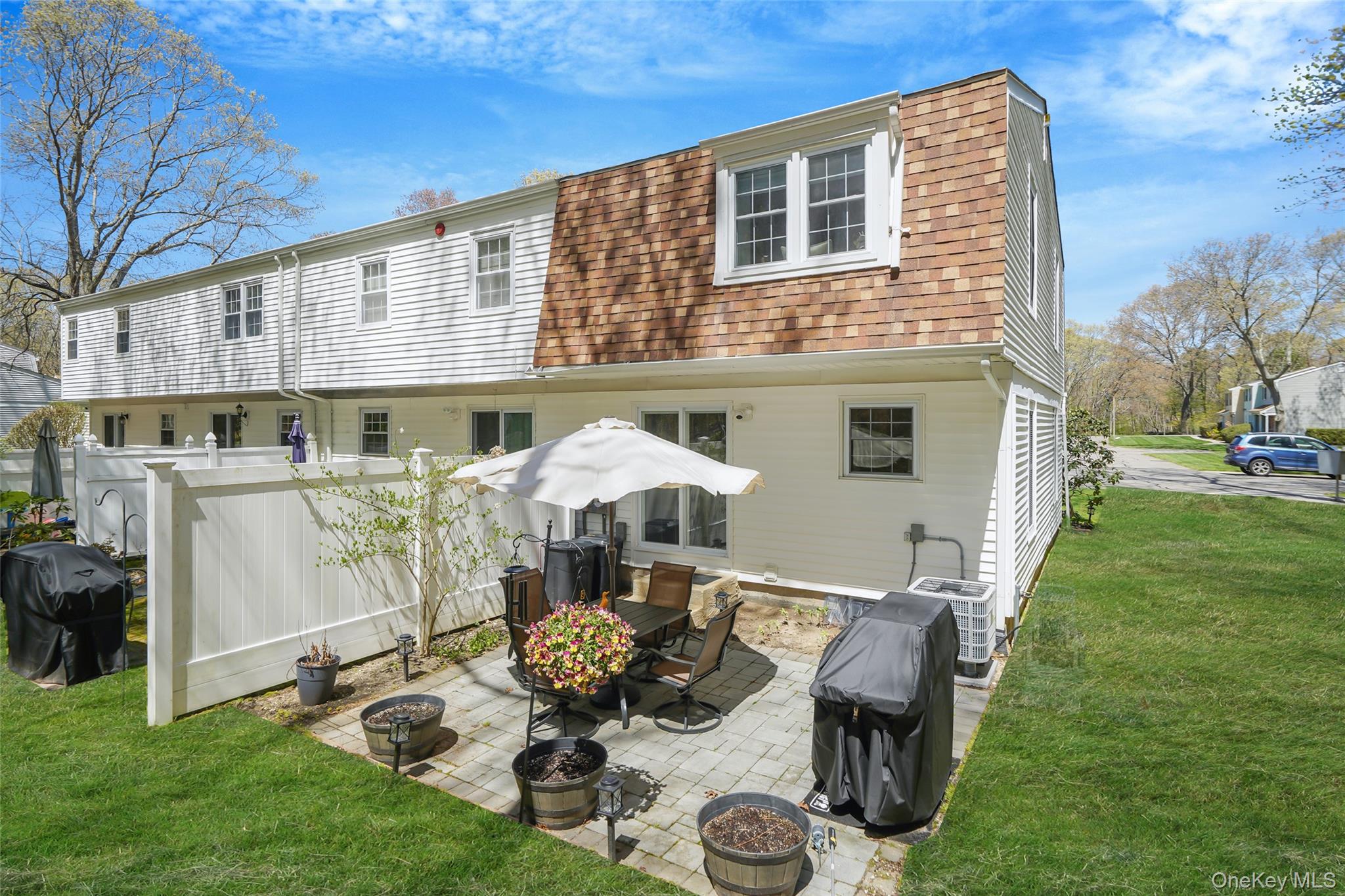 9 Penn Commons Yaphank, NY 11980 - Photo 24 of 34 a view of a patio with table and chairs under an umbrella