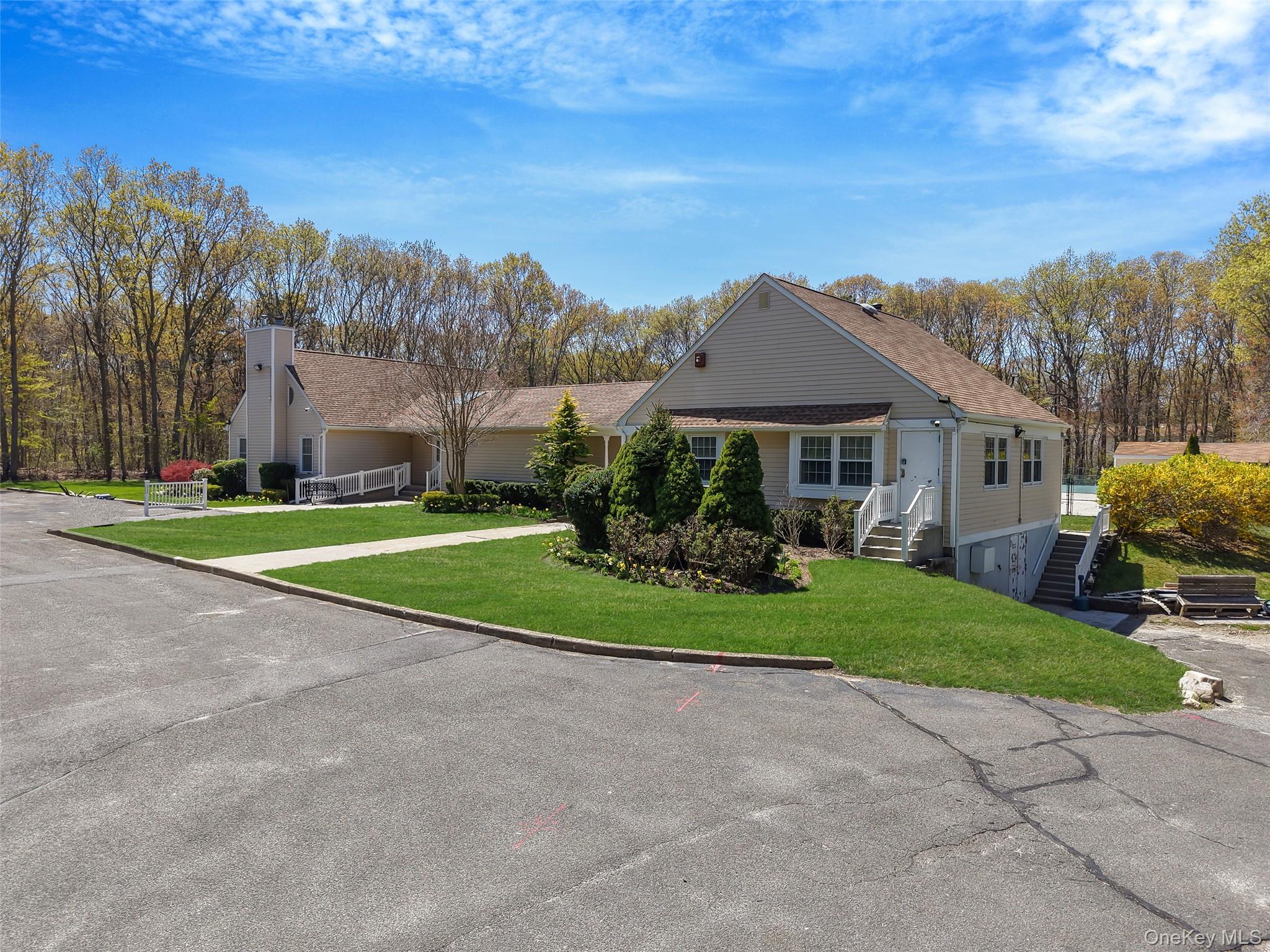 9 Penn Commons Yaphank, NY 11980 - Photo 26 of 34 a front view of a house with a yard and trees