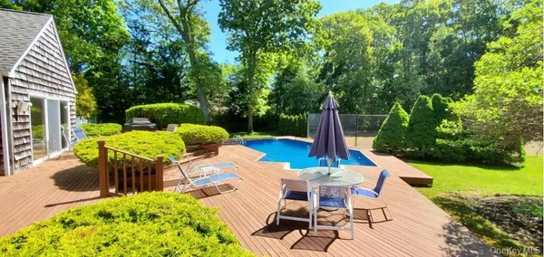 a view of backyard with swimming pool and patio