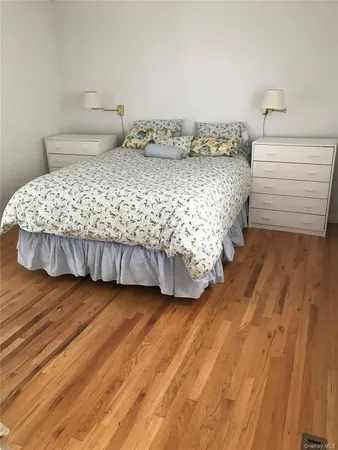 a bedroom with a bed and a wooden floor