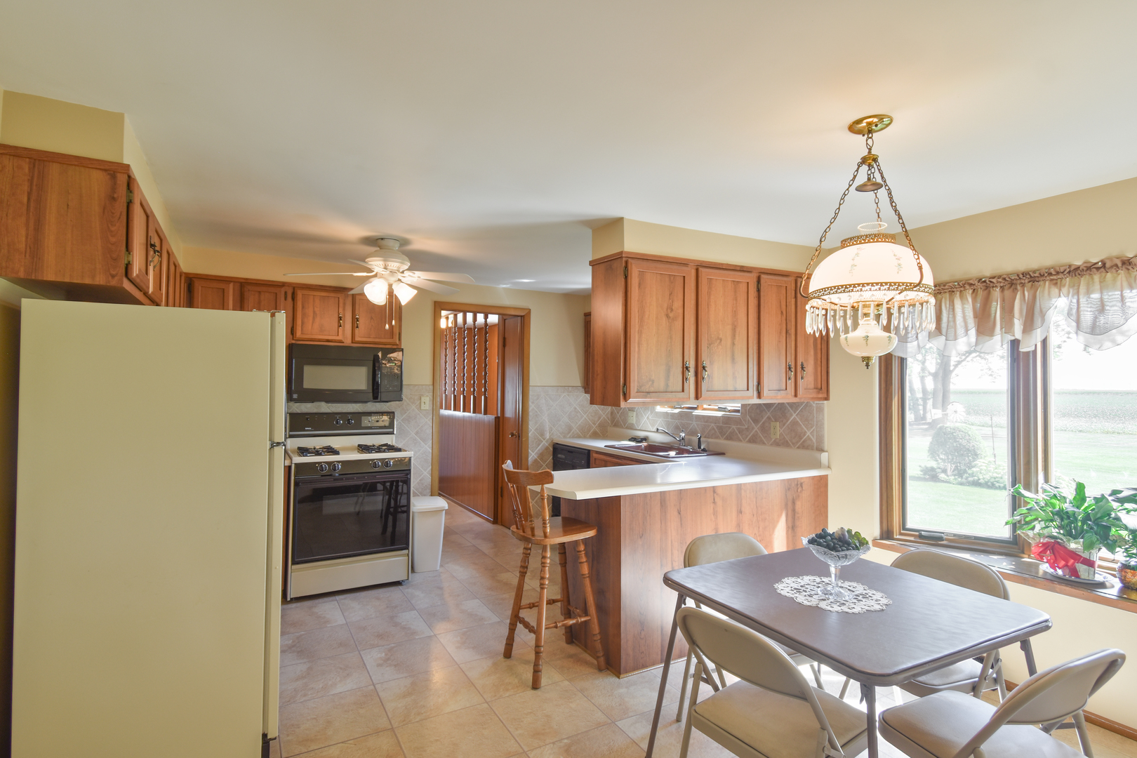 1542 East 18th Road Streator, IL 61364 - Photo 7 of 47 a kitchen with refrigerator a stove and cabinets