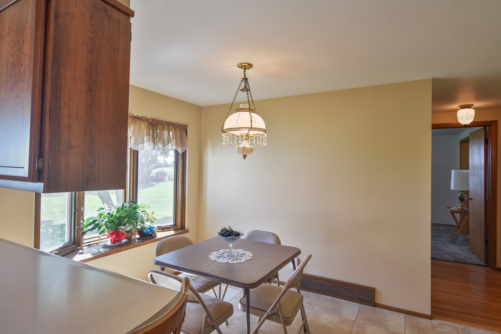 1542 East 18th Road Streator, IL 61364 - Photo 9 of 47 a dining room with wooden floor a chandelier a wooden table and chairs
