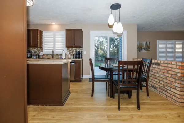 a dining room with furniture a chandelier and wooden floor