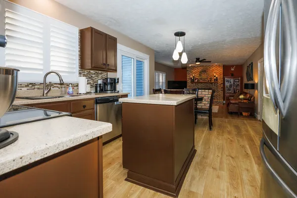 a kitchen with granite countertop a sink a counter top space stove and cabinets