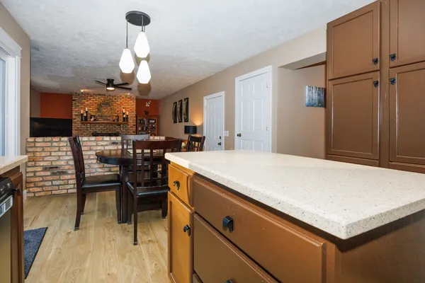 a kitchen with stainless steel appliances a stove center island a dining table and chairs