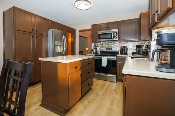 a kitchen with stainless steel appliances granite countertop a sink stove and refrigerator