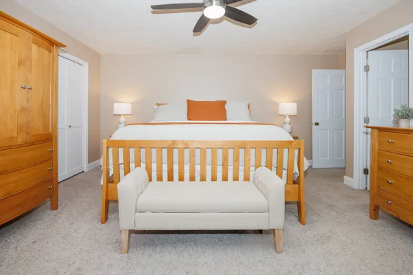 a white bed sitting in a bedroom next to a window
