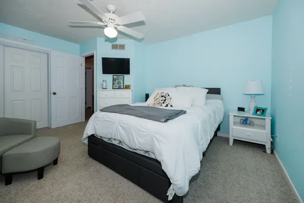 a bedroom with a bed couch tv and a window