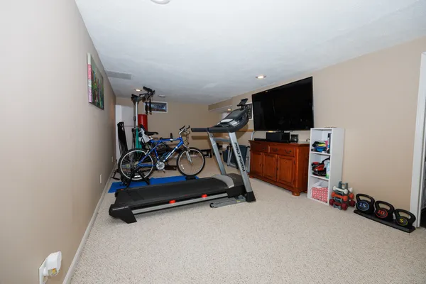 a living room with gym equipment and a flat screen tv