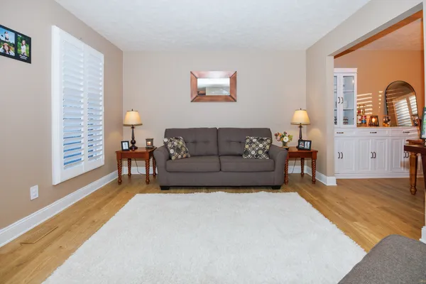 a living room with furniture and a wooden floor