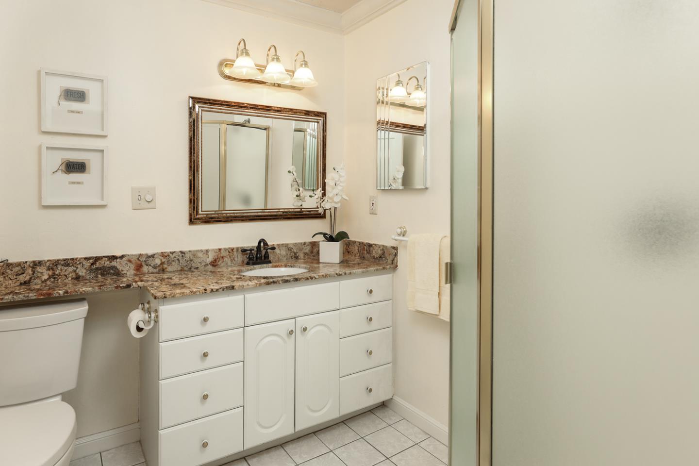 825 Parma Way Los Altos, CA 94024 - Photo 17 of 35 a bathroom with a granite countertop toilet a sink and a mirror