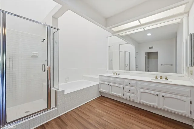 a bathroom with a tub sink shower and mirror