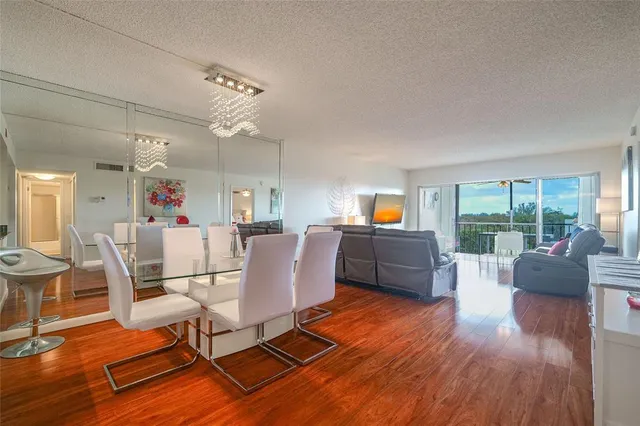 a kitchen with stainless steel appliances granite countertop white cabinets a sink a stove a microwave and a refrigerator