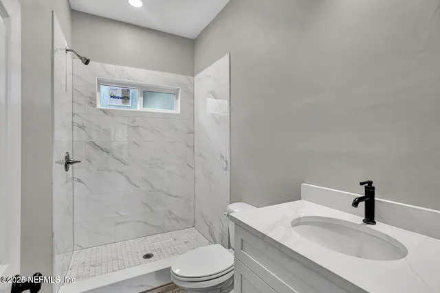 a bathroom with a sink toilet and shower