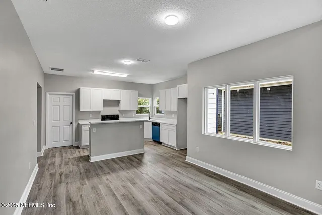 a kitchen with a refrigerator and a stove top oven