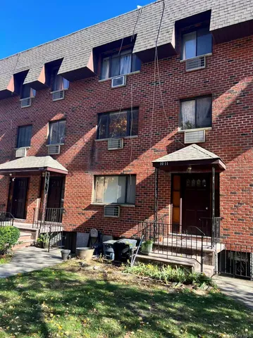 front view of a brick house with a yard