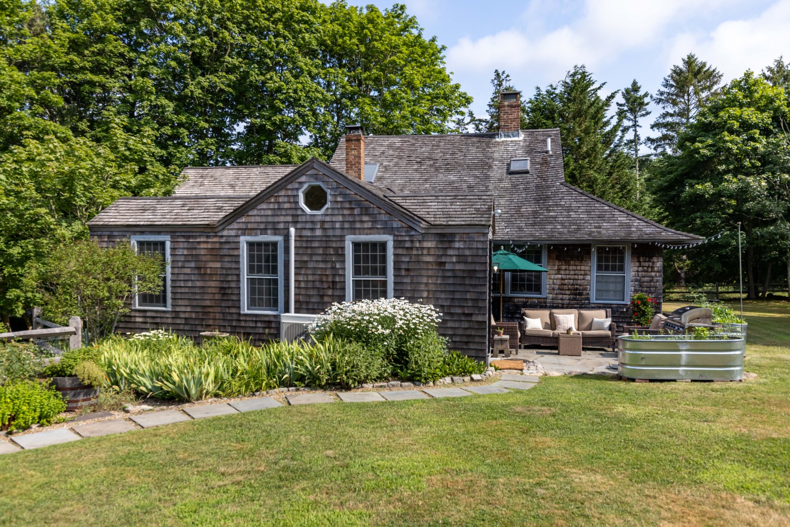 10 Danls Way West Tisbury, MA 02568 - Photo 2 of 41 a front view of a house with a garden and porch