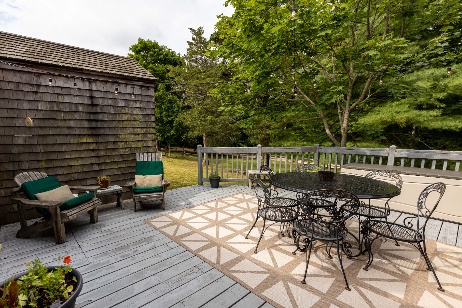 10 Danls Way West Tisbury, MA 02568 - Photo 22 of 41 a view of a patio with couches table and chairs and potted plants with wooden floor and fence